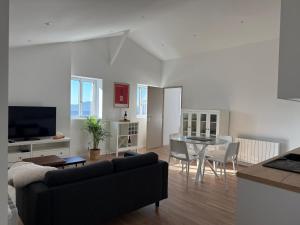 a living room with a couch and a table at ô Vignes & Bastides " L'échappée Lapébie ", appartement cosy in Sauveterre-de-Guyenne