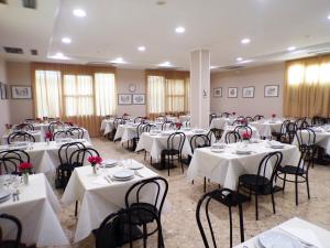 a room filled with tables and chairs with white table cloth at Hotel Adriana in Bellaria-Igea Marina