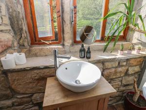 a bathroom with a bowl sink on a wooden table at Pule Hill Farm in Huddersfield +45 photos