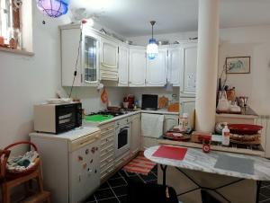 a kitchen with white cabinets and a stove top oven at Alloggio turistico MARBO in Civitavecchia
