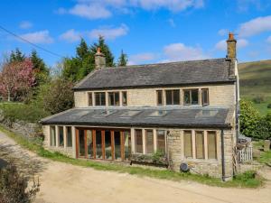 an old stone house with a solar roof at Pule Hill Farm in Huddersfield