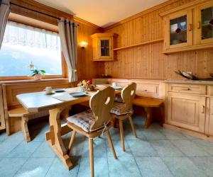 a kitchen with a wooden table and chairs at Antler Apartment in Selva di Cadore