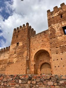 duży ceglany budynek z bramą w środku w obiekcie La casa del castillo w mieście Baños de la Encina +9 zdjęć
