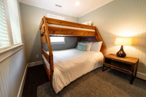 a bedroom with a wooden bunk bed with a lamp at Watermen's Hideout - Waterfront 2-Bed, 1-Bath Cottage with HOT TUB & Private Dog Run! in Waves +32 photos