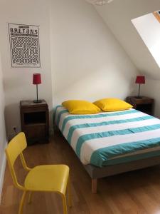 a bedroom with a bed and a yellow chair at Le Tertre de la Nouette in La Bosse-de-Bretagne