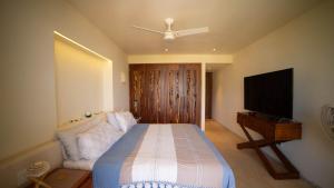 ein Schlafzimmer mit einem Bett und einem Flachbildfernseher in der Unterkunft Luxury Penthouse at Aura del Mar in Zihuatanejo