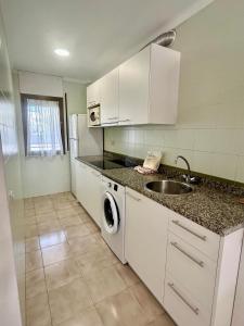 a kitchen with a sink and a washing machine at Alojamientos familiares Sa Gavina Estartit, Principal in L'Estartit +78 photos