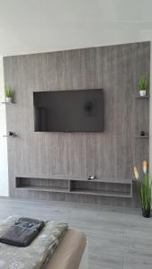 a living room with a flat screen tv on a wall at White Harmony Apartment in Debrecen +38 photos