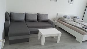 a living room with a couch and a table at White Harmony Apartment in Debrecen
