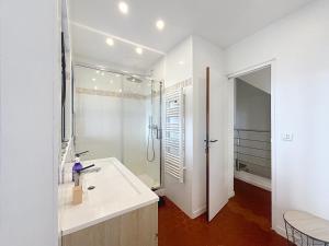 Un baño blanco con lavabo y ducha. en Les Verdalettes, en Saint-Paul-de-Vence