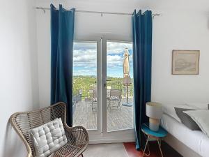 1 dormitorio con 1 cama y ventana con vistas a un patio en Les Verdalettes, en Saint-Paul-de-Vence