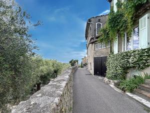 Una calle vacía al lado de un muro de piedra al lado de un edificio en Les Verdalettes, en Saint-Paul-de-Vence