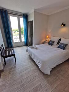 a bedroom with a large bed and a large window at Source de la Vallée in Sadroc