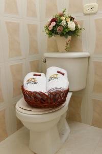a bathroom with a toilet with a basket of towels at La Casa del Turista in Tauramena