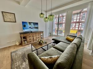 a living room with a couch and a table at MEL&BENS Altstadt Suites mit Parkoption in Celle