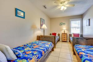 a bedroom with two beds and a ceiling fan at St Augustine Island Cottage - Walk to Beach in Saint Augustine