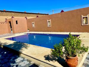 a swimming pool in front of a house at Dar Hassi Labied Merzouga in Adrouine