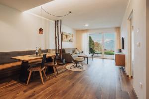 a living room with a table and chairs and a couch at Pataunerhof Tirol in Tirolo