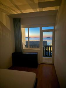 a room with a bed and a large window at BALATON A KERTBEN - BALATON IN THE GARDEN - Beachfront houses with beautiful view, private beach in Balatonfenyves