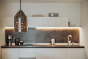 a kitchen with a sink and a pendant light at Pataunerhof Tirol in Tirolo