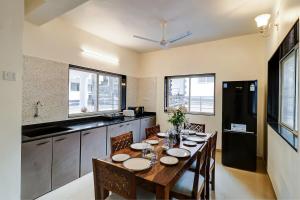 a kitchen with a wooden table with chairs and a dining room at Aqua Villa, Esperanza by Svar Stays with Breakfast, Swimming Pool view & Valley View in Panchgani
