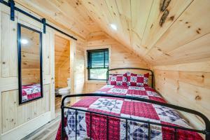 a bedroom with a bed in a wooden cabin at Near Mammoth Cave Family-Friendly Cabin with Patio! in Cave City