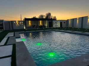 ein Schwimmbecken mit grünen Lichtern im Wasser in der Unterkunft Pelicanos Residencial in Puerto Peñasco