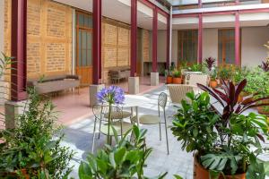 a patio with tables and chairs and plants at Casa Rosada in Bogotá
