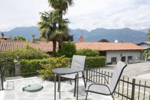 a patio with two chairs and a table and a fence at La DaMa in Germignaga