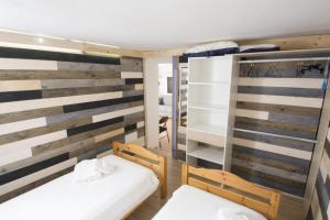 two beds in a room with wooden walls at La DaMa in Germignaga