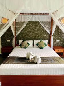 two stuffed animals are sitting on a bed at Rainforest Resort Prey Areng in Phumĭ Triĕt