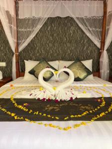 two swans making a heart on a bed at Rainforest Resort Prey Areng in Phumĭ Triĕt