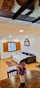 ein Schlafzimmer mit einem Bett und einem Tisch mit Blumen in der Unterkunft Casas Cor de Rosa in São Martinho das Moitas