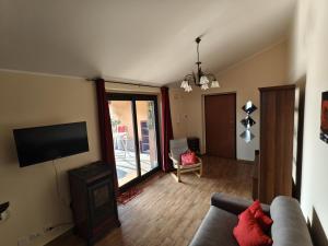 a living room with a couch and a flat screen tv at Casa Rosy Sicilia in Brolo