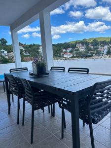 a black table with chairs and a view of the water at Hvar beach vacation in Vrboska