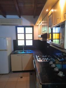 eine Küche mit Spüle und Herd oberen Backofen in der Unterkunft Casa Hogareña, Valle del Espíritu Santo in El Valle del Espíritu Santo