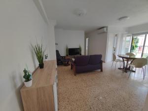 a living room with a blue couch and a table at Au bord de la plage in Puerto de Sagunto