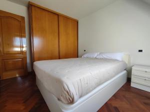 a white bed in a room with a wooden door at Apartamento centro de Sada in Sada