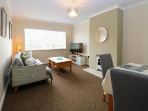 a living room with a couch and a table at Little Lodge in Dersingham