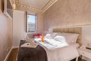 a bedroom with a large white bed with a window at Piazza Venezia appartamento con vista in Rome
