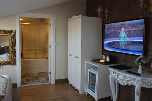 baño con TV en la pared y bañera en Diamond Royal Hotel, en Estambul