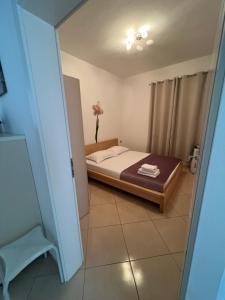 a bedroom with a bed and a vase with a flower at Apartment Alexis Stefanos in Himare