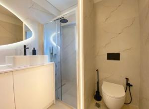 a bathroom with a toilet and a glass shower at GP Castle Patras in Patra +17 photos