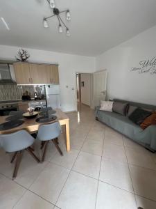 a kitchen and a living room with a table and a couch at Apartment Alexis Stefanos in Himare +10 photos