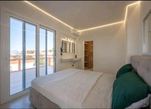 a bedroom with a large bed and a large window at GP Castle Patras in Patra