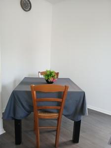 a table with a blue table cloth and a plant on it at gîte in Malafretaz