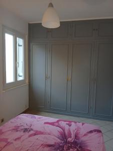 a bedroom with a pink bed and some cabinets at gîte in Malafretaz