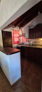 eine Küche mit Holzschränken und einer weißen Arbeitsplatte in der Unterkunft Casa de Campo in San Isidro