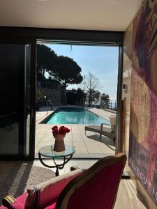 a living room with a glass table and a pool at Villalino Tre Palme, Pool, 2 Schlafzimmer, 2 Bäder, Pool, Terrasse, Outdoor Fitness in Alassio
