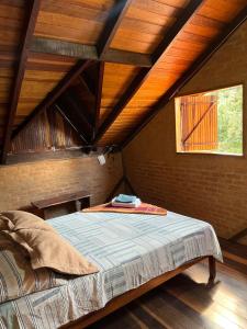 a bed in a room with a wooden ceiling at Chale Nha Chica in Alagoa